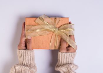 Top view Hand holding gift box on work space